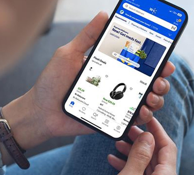 A person holding a smartphone with the Walmart app open
